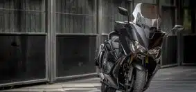 black and silver motorcycle parked on sidewalk during daytime