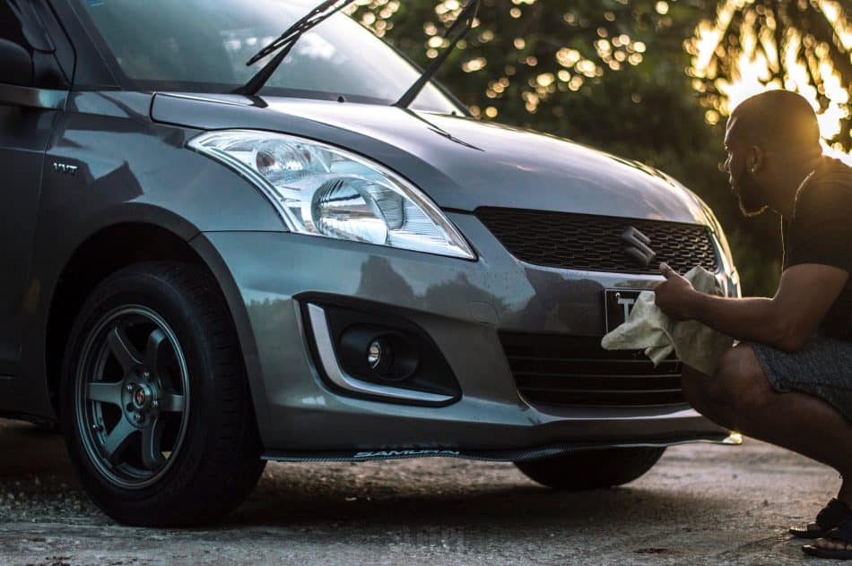 Photo d’un homme lavant la carrosserie de sa voiture illustrant l’article sur la bonne façon de nettoyer sa voiture