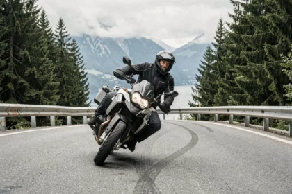 Motard en pleine courbe sur la route alpine près de Thonon-les-Bains avec vue sur le lac Léman en arrière-plan